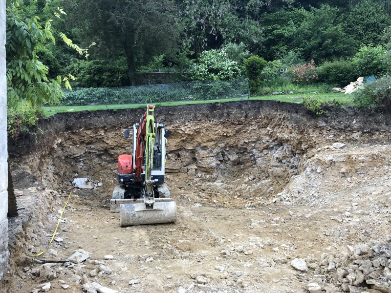 digger digging earth on slope in garden