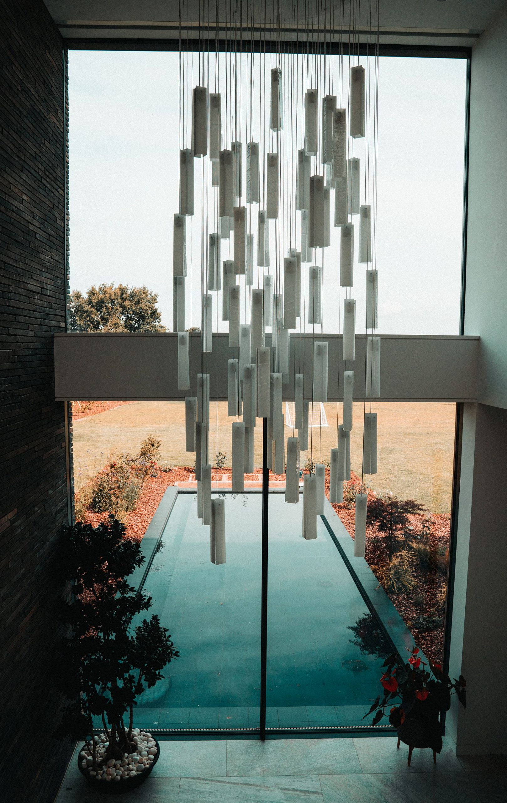 A big chandelier handing in an open hallway.