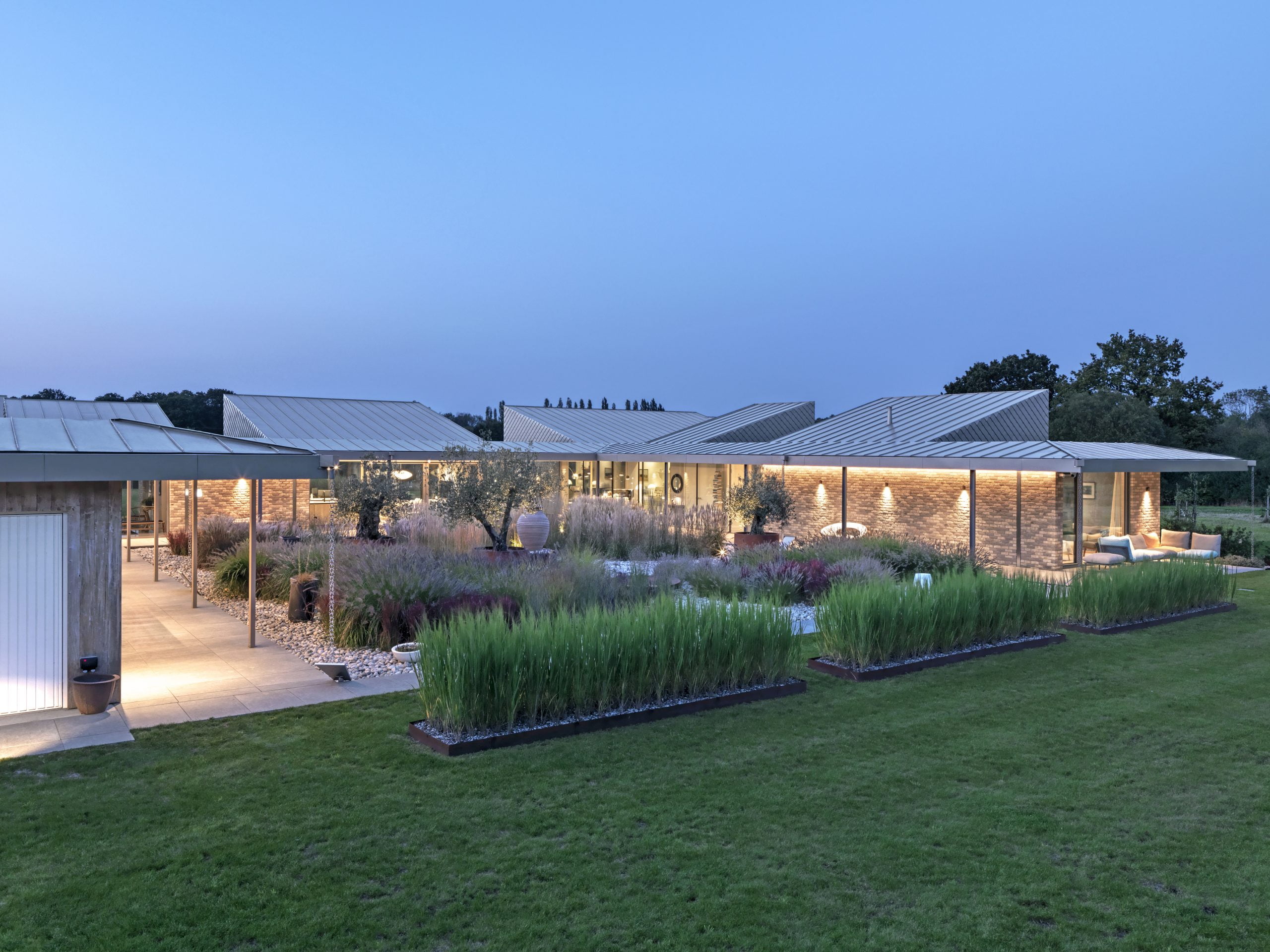 A modern garden with a courtyard and a row of small hedges.