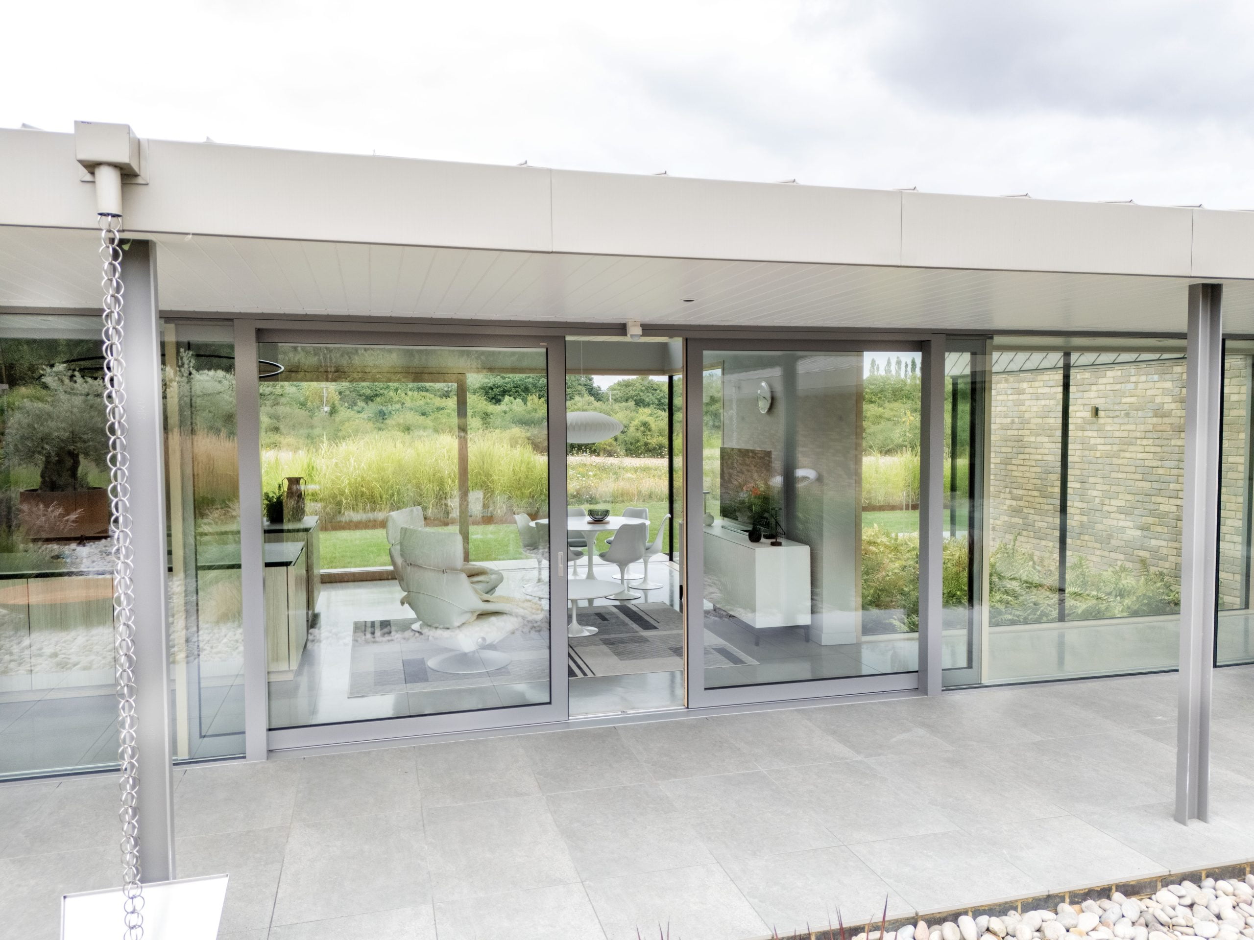 A modern home with large glass sliding doors and floor to ceiling windows.